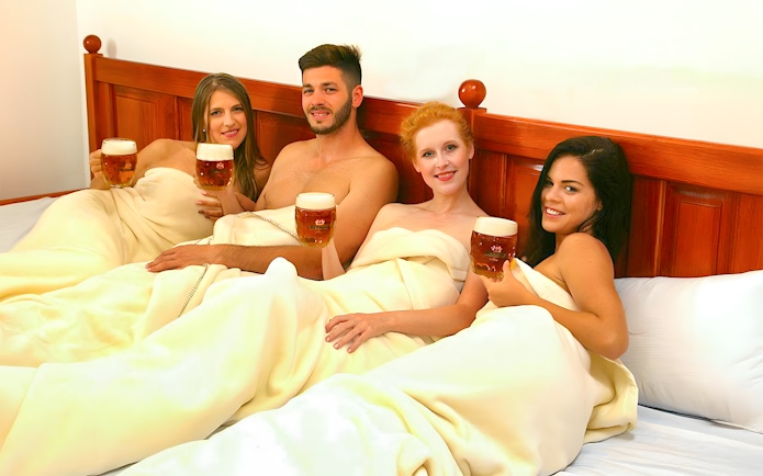 Guests enjoying beer on a heated bed at Bernard Beer Spa.