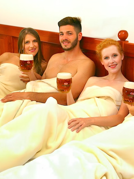 Guests enjoying beer on a heated bed at Bernard Beer Spa.