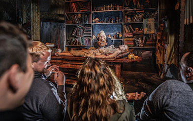 Audience watching Plague act in Hamburg Dungeon with actor and patient on table.