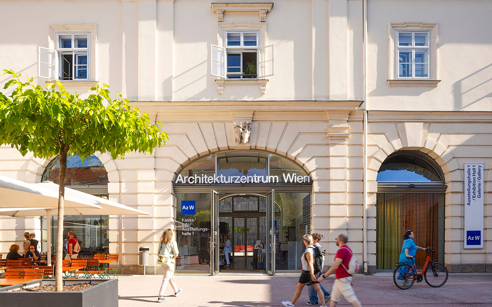 Architekturzentrum Wien entrance with people walking and cycling nearby.