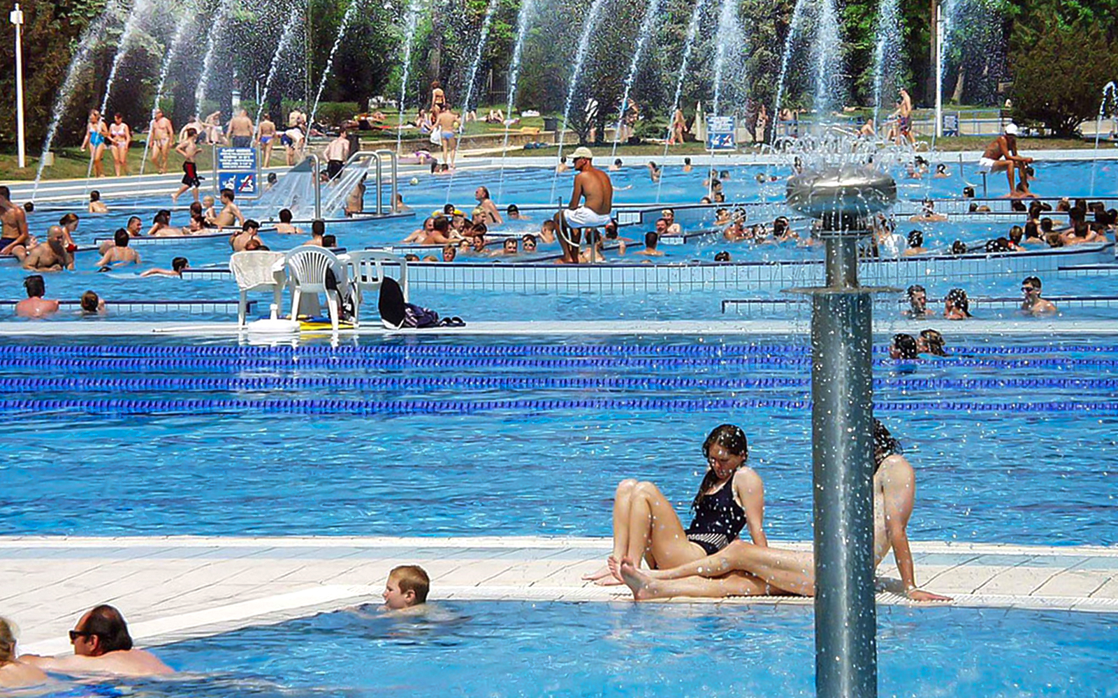 Guests relaxing in outdoor pools at Palatinus Spa, Budapest.