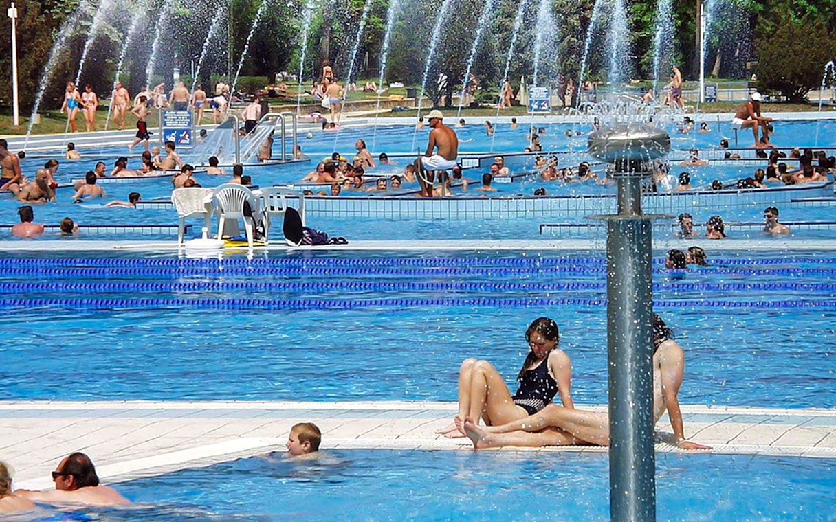 Guests relaxing in outdoor pools at Palatinus Spa, Budapest.