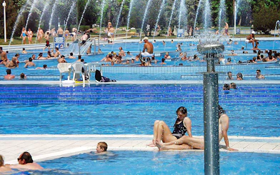Guests relaxing in outdoor pools at Palatinus Spa, Budapest.