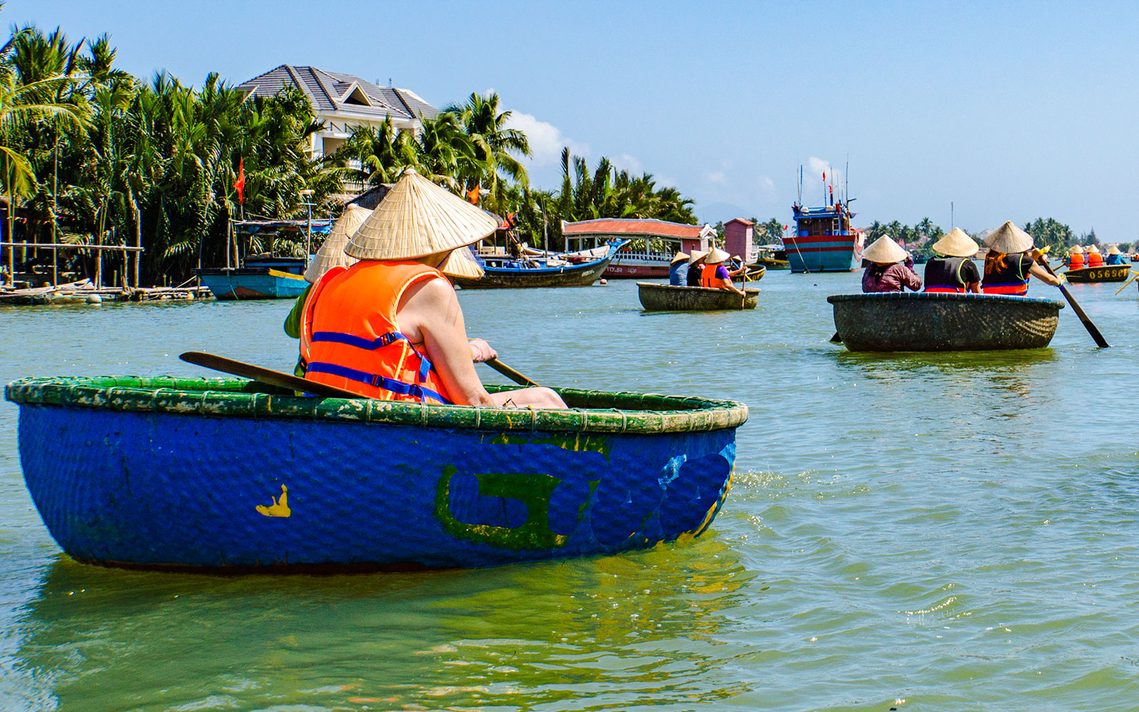 People rowing bamboo basket boats on a river in Vietnam.