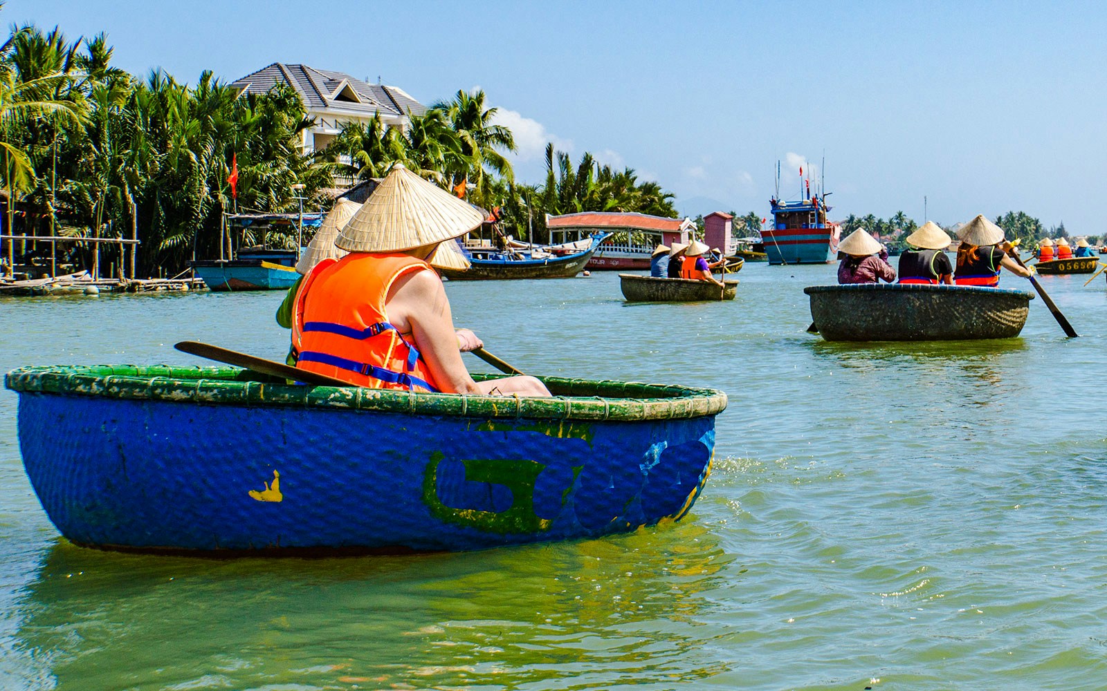 People rowing bamboo basket boats on a river in Vietnam.