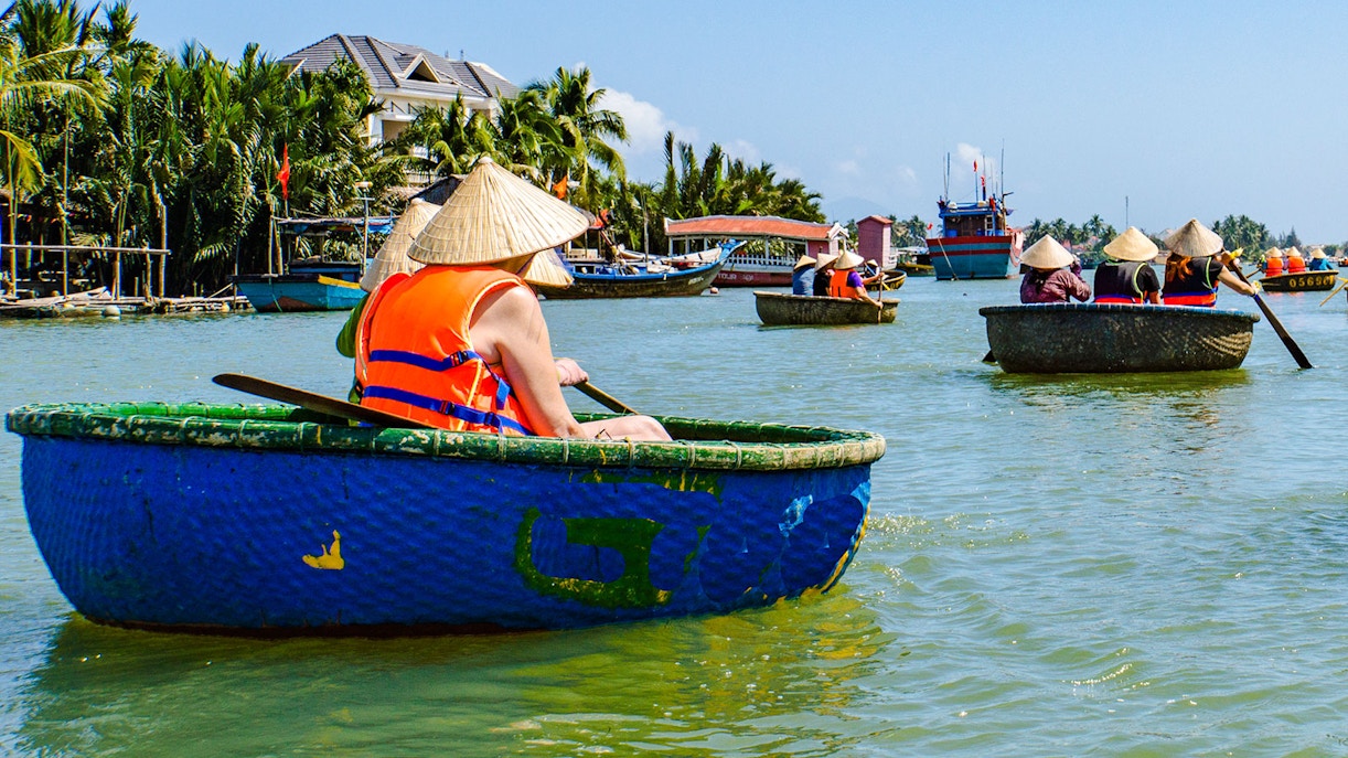 People rowing bamboo basket boats on a river in Vietnam.