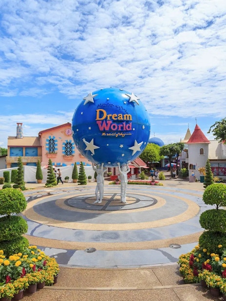 Dream World Bangkok entrance with globe sculpture and colorful gardens.