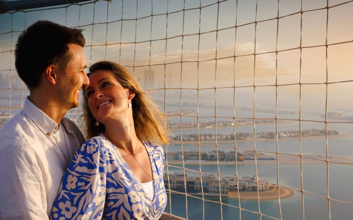 Couple enjoying view from The Dubai Balloon at Atlantis, overlooking Palm Jumeirah.