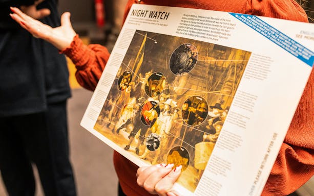 Guide explaining Rembrandt's Night Watch during Amsterdam Food & History Tour