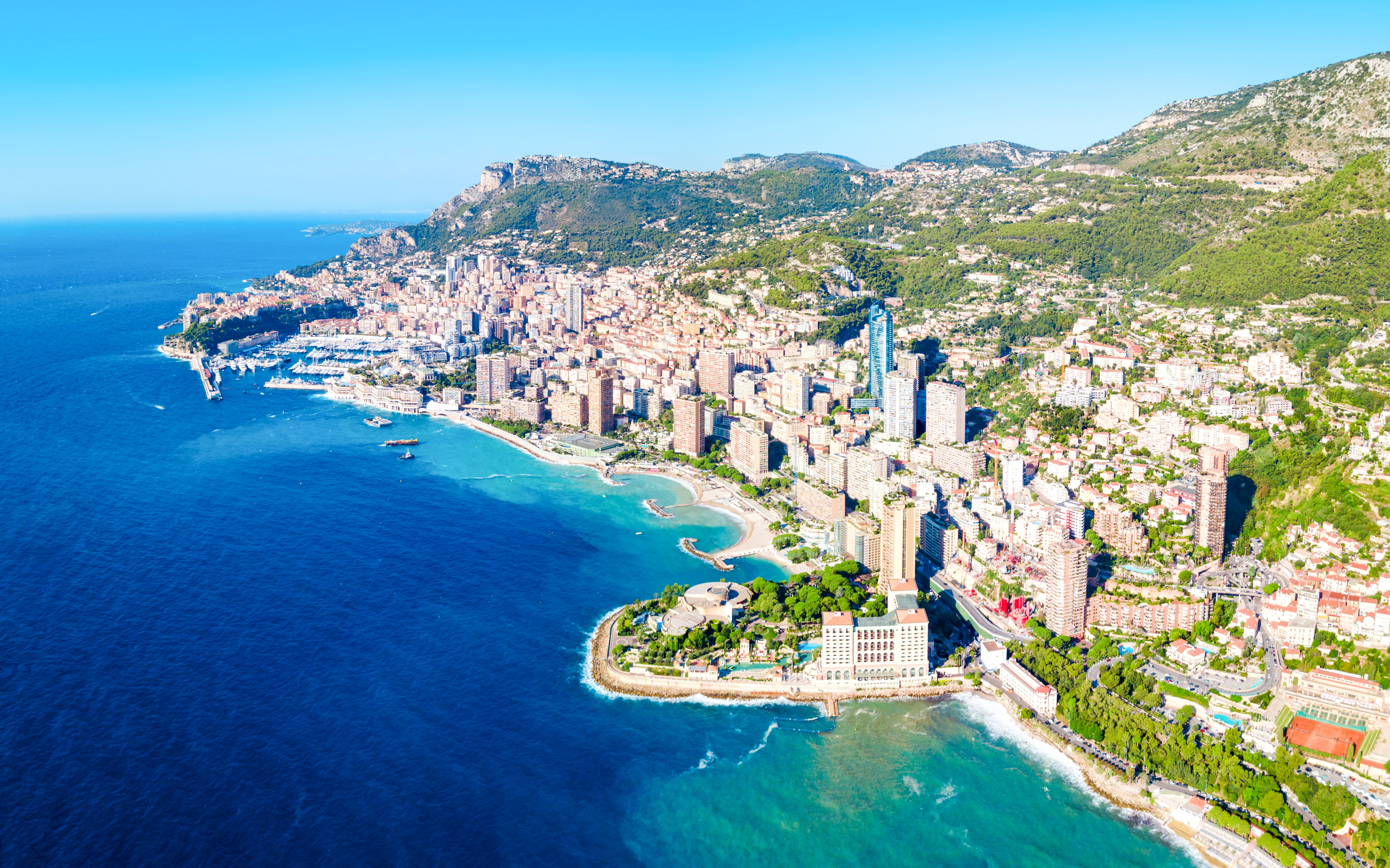 Aerial view of Monaco coastline with cityscape and Mediterranean Sea.