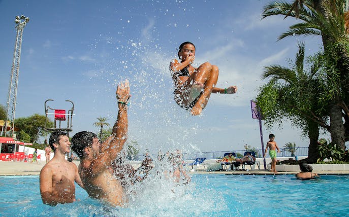Child being tossed in pool at Illa Fantasia Water Park, Barcelona.