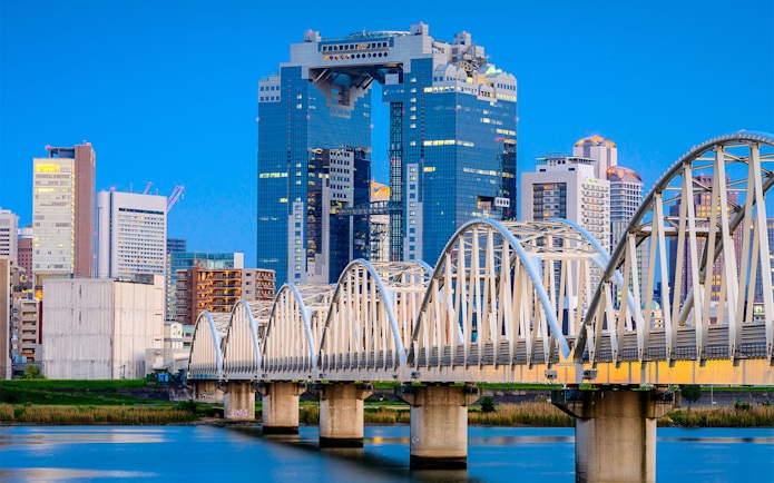 Umeda Sky Building and bridge in Osaka, Japan, viewed from the river.