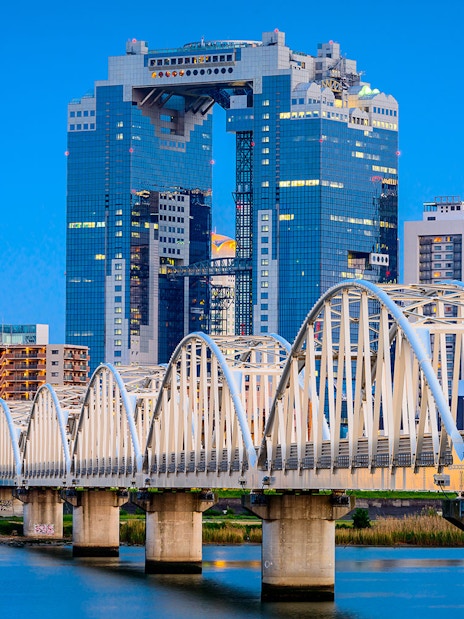 Umeda Sky Building and bridge in Osaka, Japan, viewed from the river.