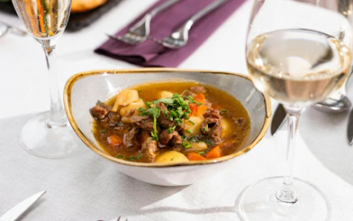 Traditional Hungarian goulash served with wine on Budapest Dinner Cruise.