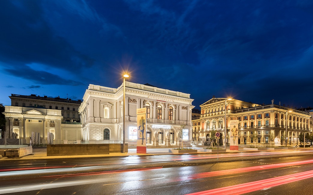 ALBERTINA MODERN museum in Vienna illuminated at night with street view.