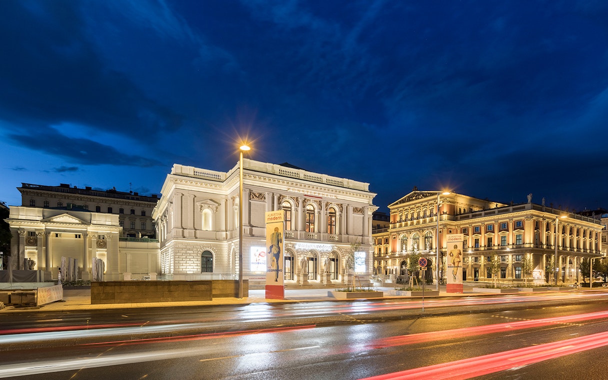 ALBERTINA MODERN museum in Vienna illuminated at night with street view.