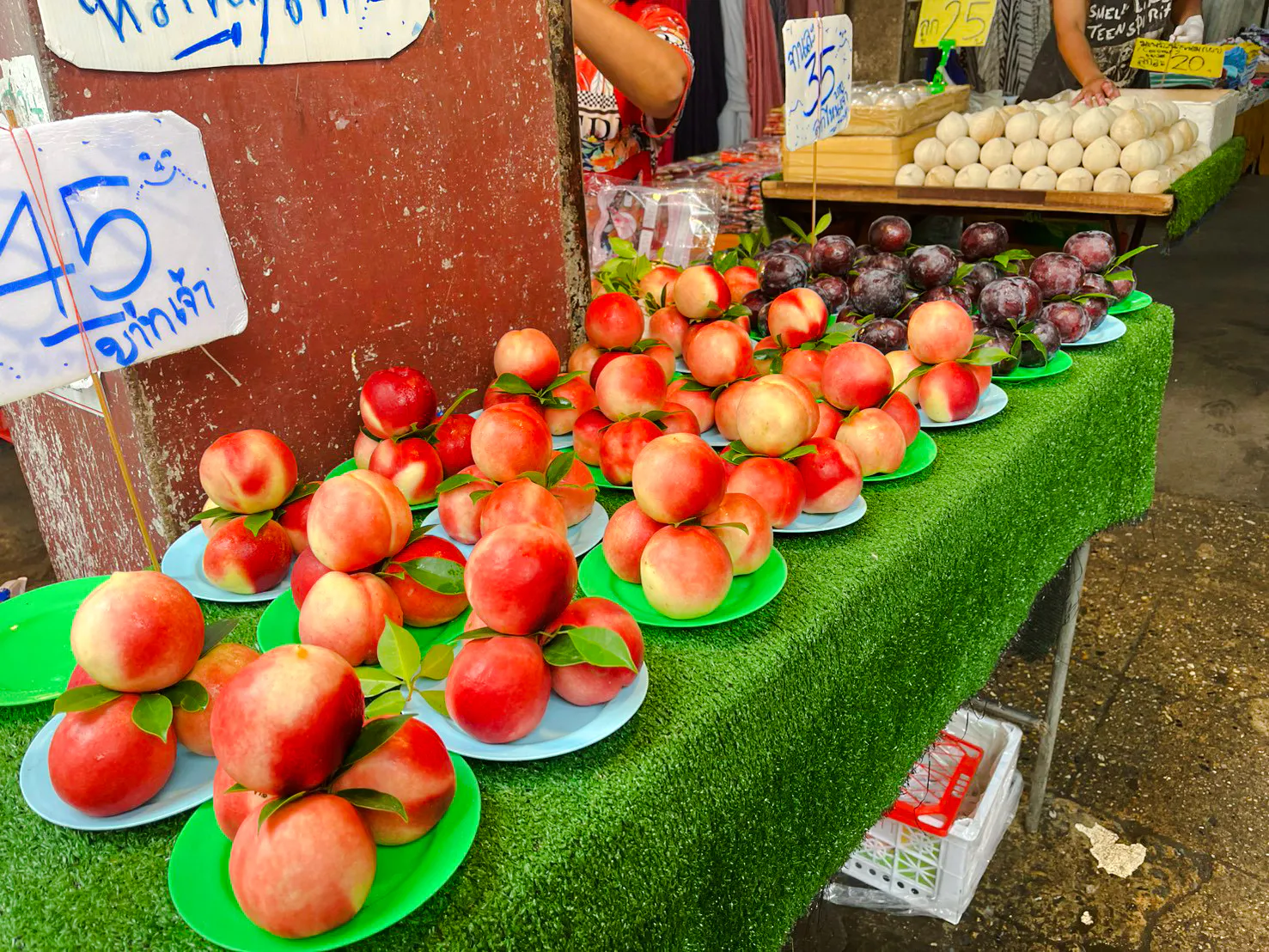 Fresh peaches and plums on display at a Chiang Mai market during the Michelin Food Walking Tour.