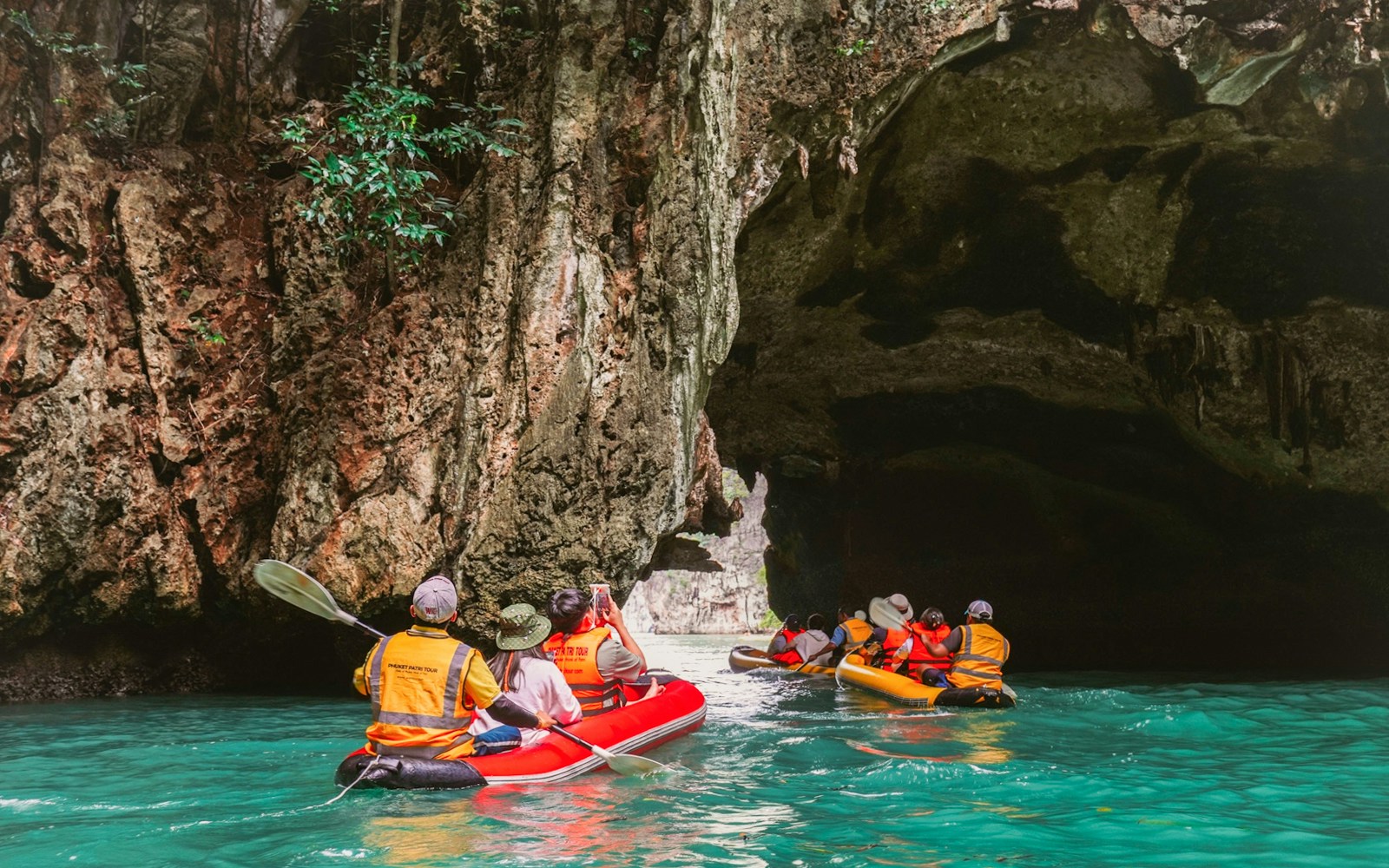 Kayakers explore limestone caves on James Bond Island, Phuket, during sunset tour.