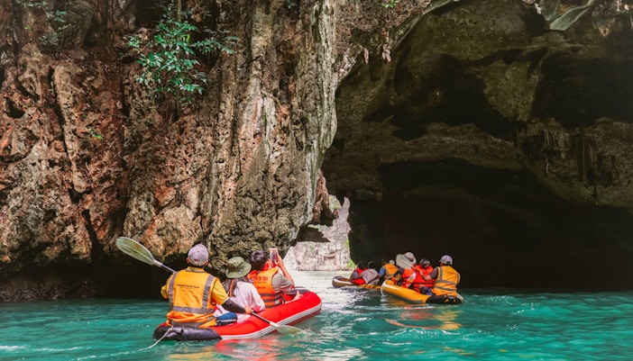 Kayakers explore limestone caves on James Bond Island, Phuket, during sunset tour.