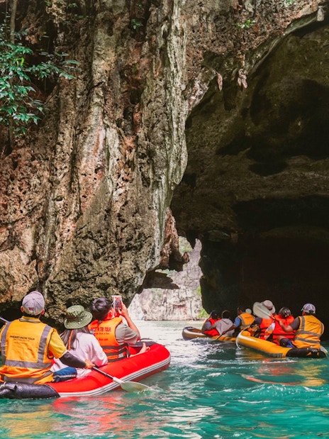 Kayakers explore limestone caves on James Bond Island, Phuket, during sunset tour.