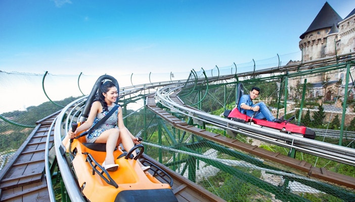 Couple enjoying Alpine Coaster ride at Ba Na Hills, Da Nang, Vietnam.