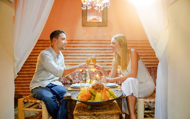Couple enjoying dinner at Dar Essalam Moroccan show.