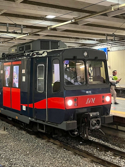 Campania Express train at a station platform in Italy.