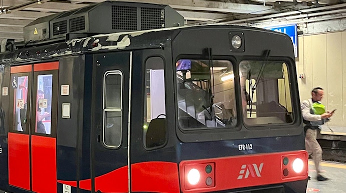Campania Express train at a station platform in Italy.