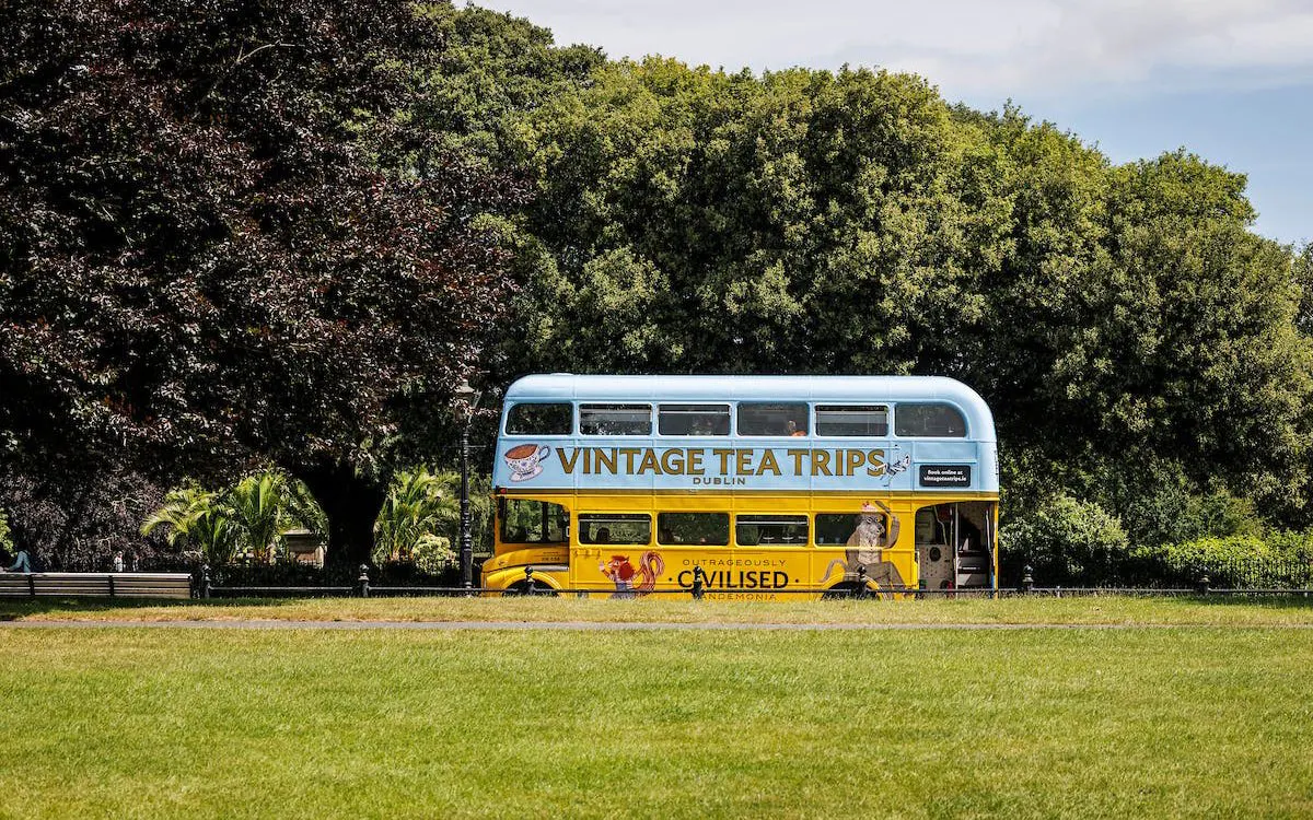 Vintage double-decker bus for tea tours in Dublin park setting.