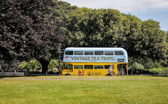 Vintage double-decker bus for tea tours in Dublin park setting.