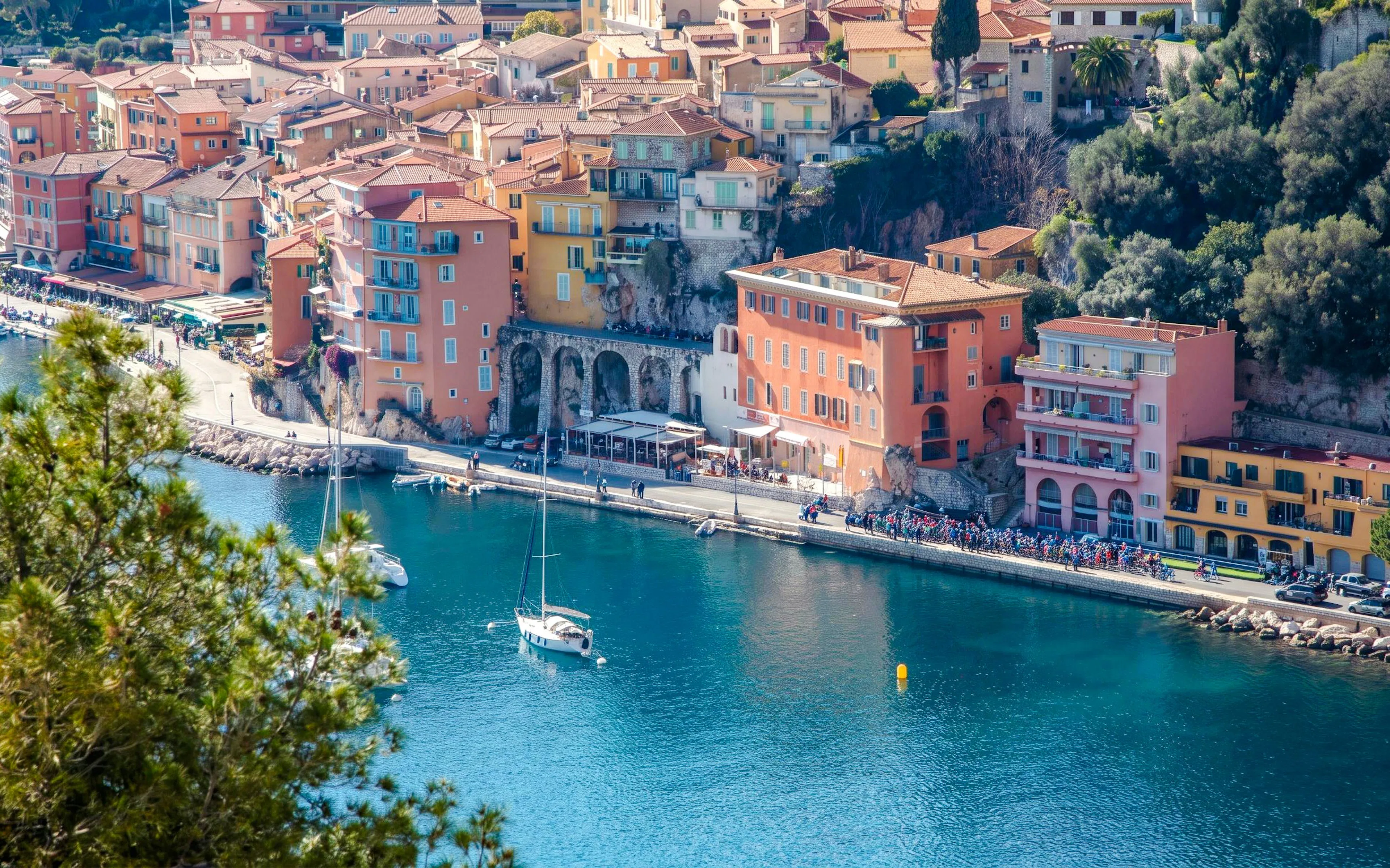 Villefranche coastline with colorful buildings and sailboats in the harbor.