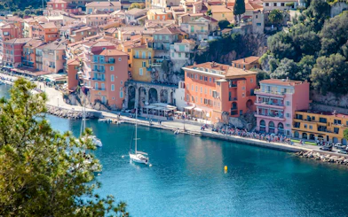 Villefranche coastline with colorful buildings and sailboats in the harbor.