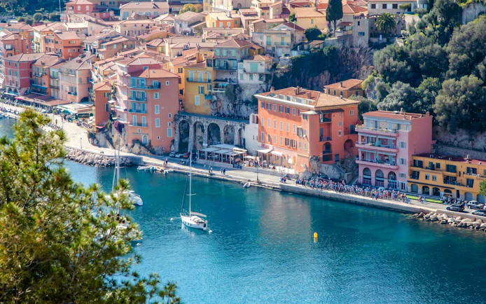 Villefranche coastline with colorful buildings and sailboats in the harbor.