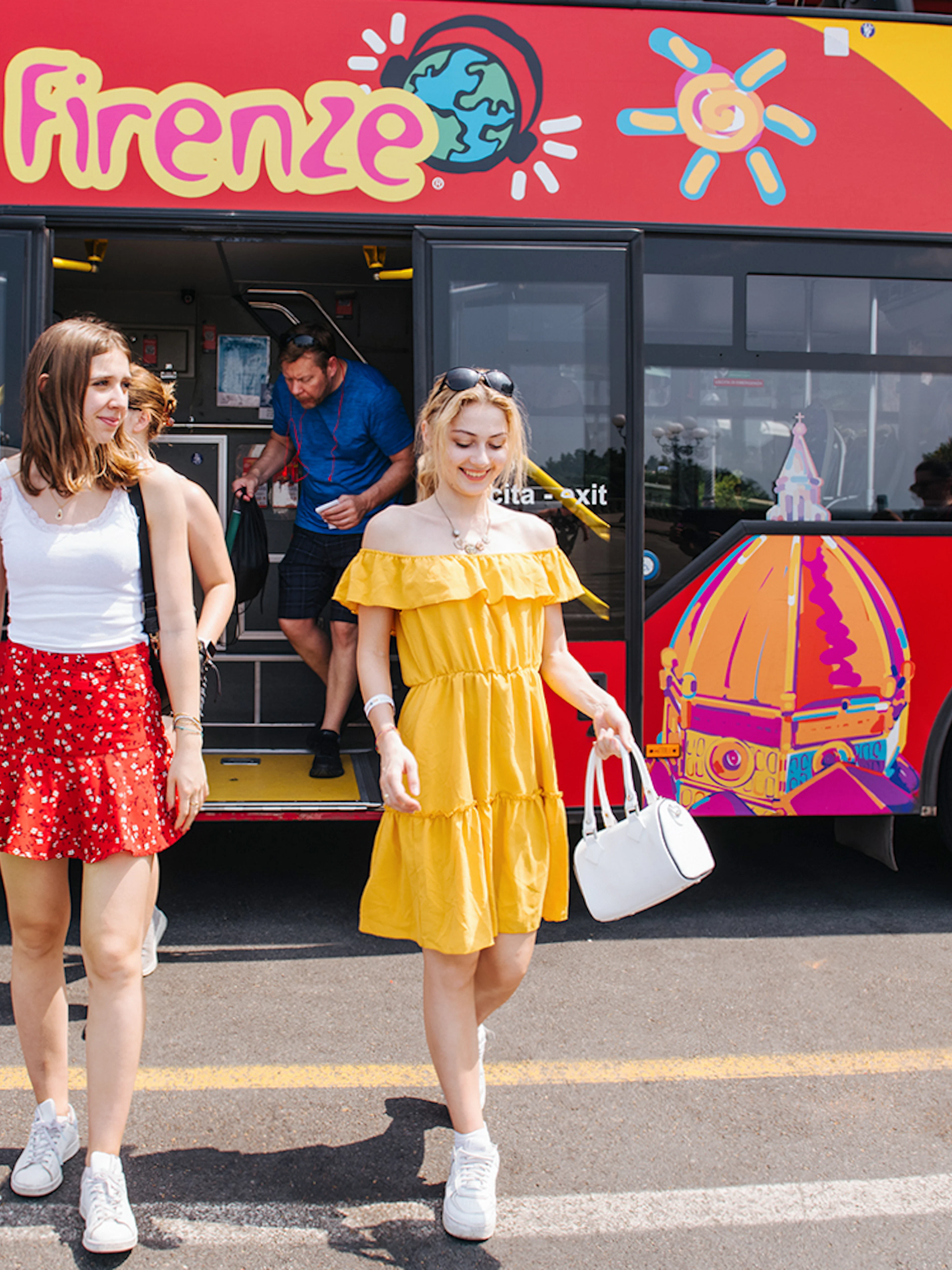 Women walking by a CitySightseeing bus in Florence, Italy.