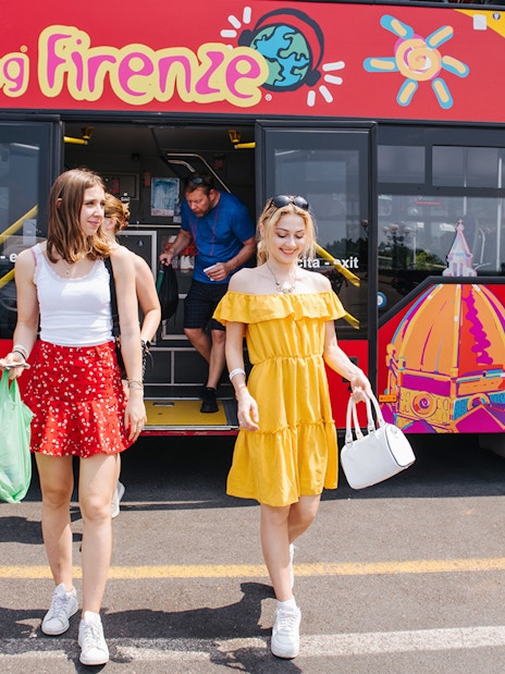 Women walking by a CitySightseeing bus in Florence, Italy.
