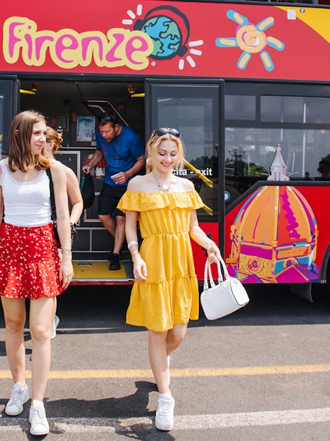 Women walking by a CitySightseeing bus in Florence, Italy.