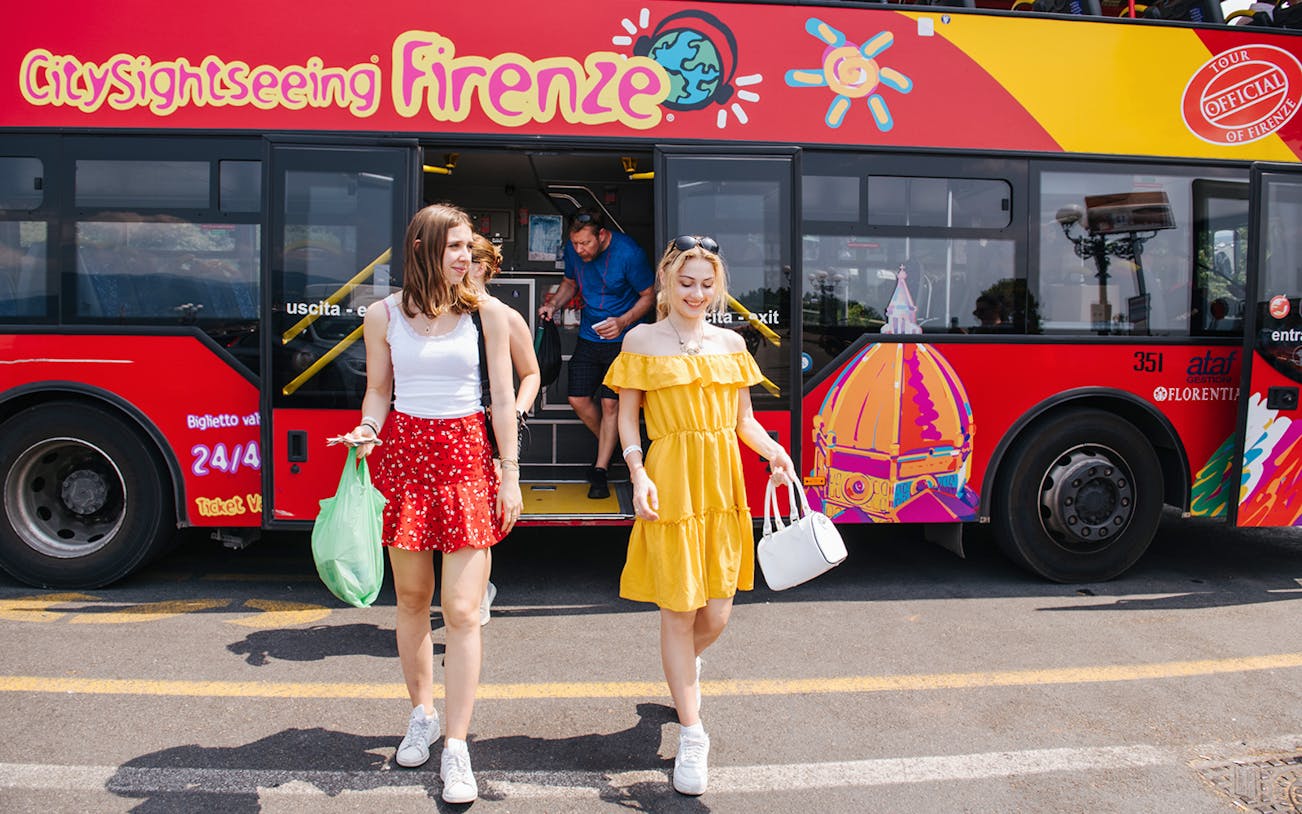 Women walking by a CitySightseeing bus in Florence, Italy.
