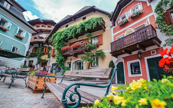 Colorful houses and benches in Hallstatt village, Austria, seen on a day trip from Vienna.