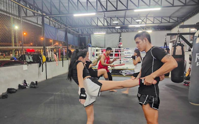 Beginners practicing Muay Thai kicks in a Pattaya boxing gym.