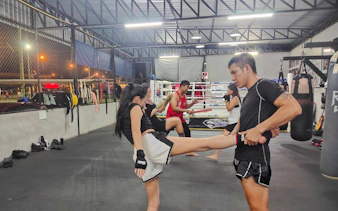 Beginners practicing Muay Thai kicks in a Pattaya boxing gym.