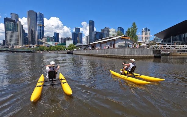 Waterbikes on Yarra River with Melbourne skyline in the background.