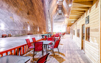 Seating area inside Slanic Salt Mine with wooden walls and tables.