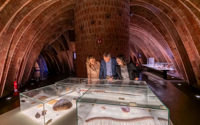 Tourist with guide examining artifacts in Casa Mila museum, Barcelona.