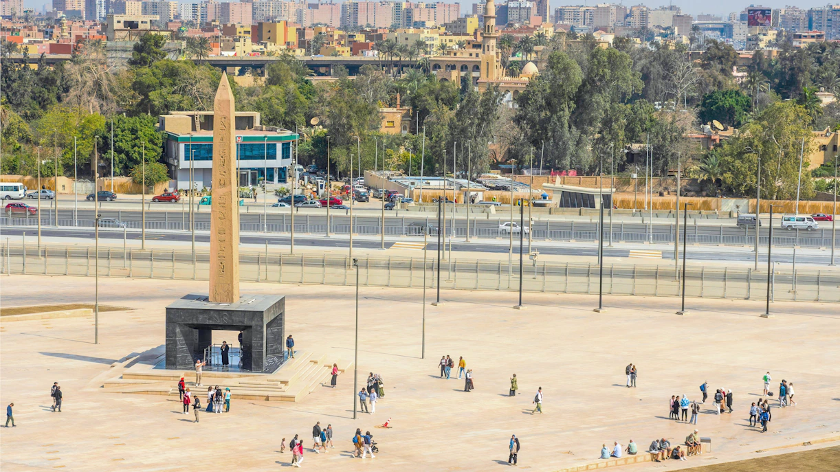 Hanging Obelisk at Grand Egyptian Museum with visitors exploring the plaza.