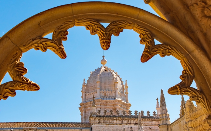 Jeronimos Monastery dome framed by ornate arch, Lisbon, Portugal.