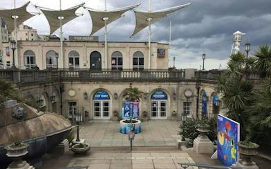 Brighton seafront entrance with palm trees and colorful mural, part of self-guided city exploration game.