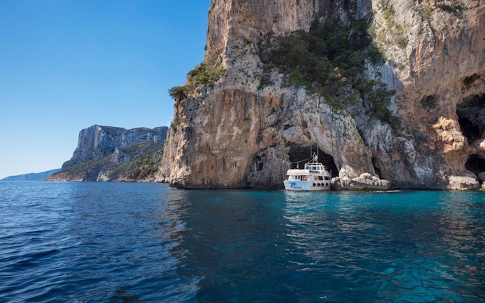 Boat approaching cave entrance at Gulf of Orosei, Italy.