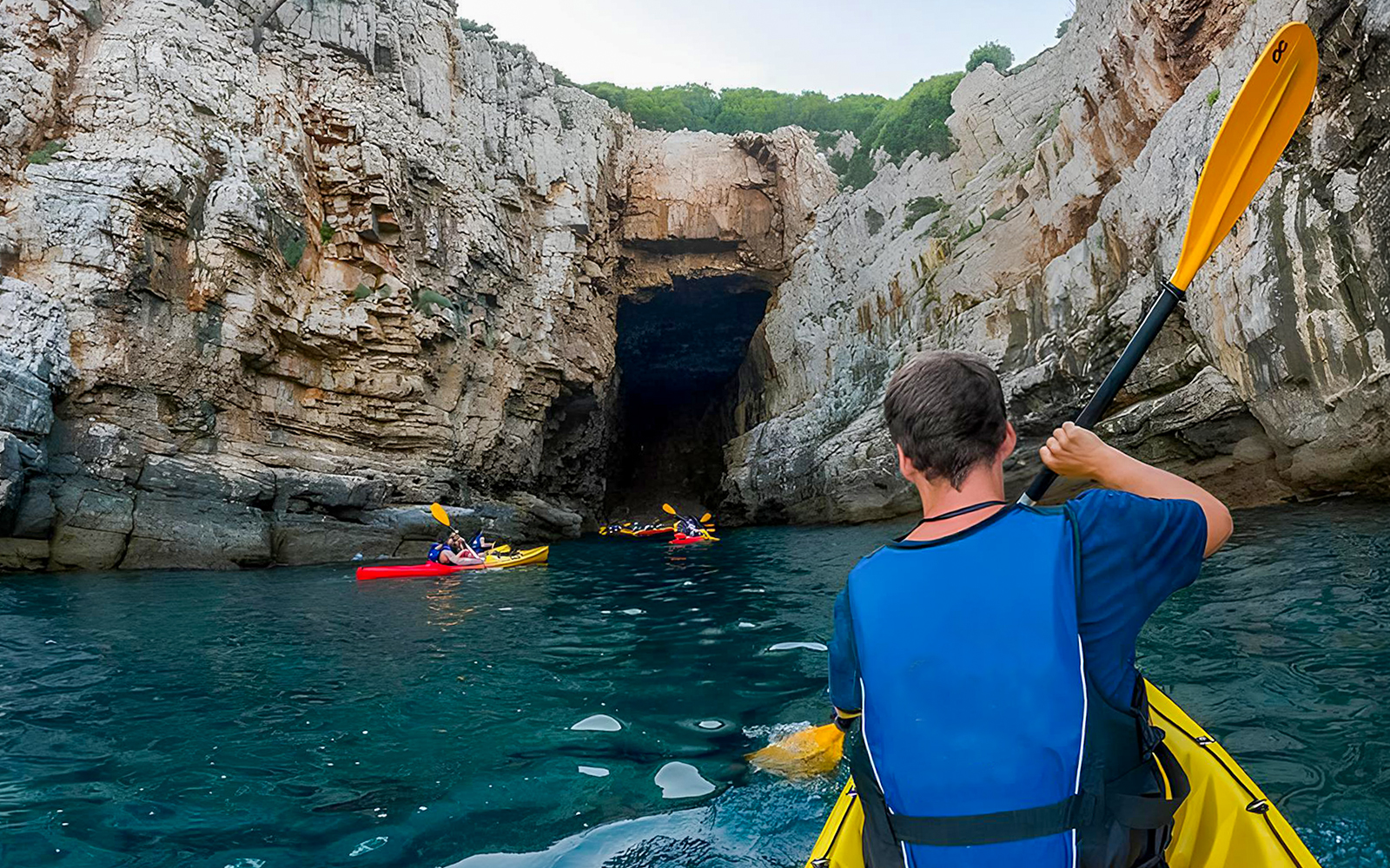 Kayakers paddling towards Betina Cave in Dubrovnik during morning.