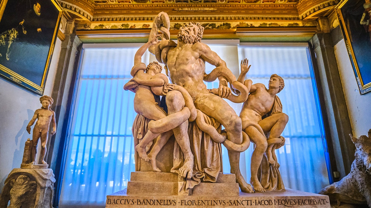 Visitors exploring the Vasari Corridor with views of Florence's Uffizi Gallery.