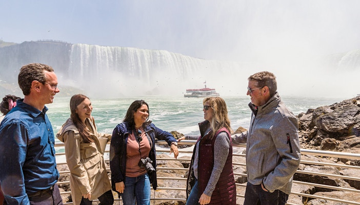 Tourists viewing Niagara Falls from a viewpoint.